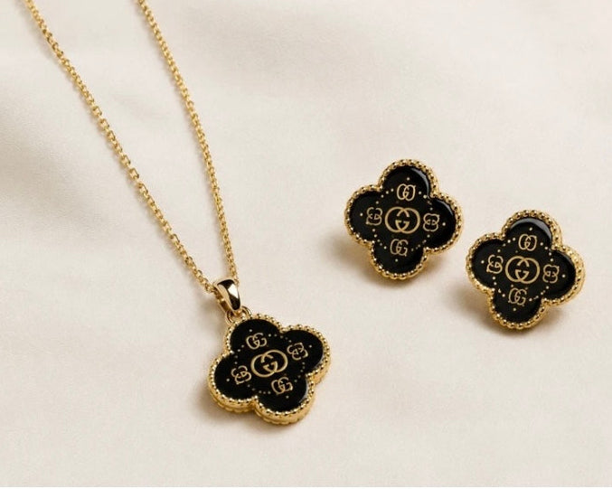 Woman Wearing Black Clover Pendant Necklace and Stud Earrings
